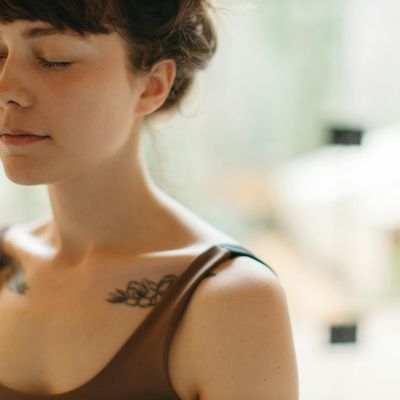 Person in a meditative pose with eyes closed.